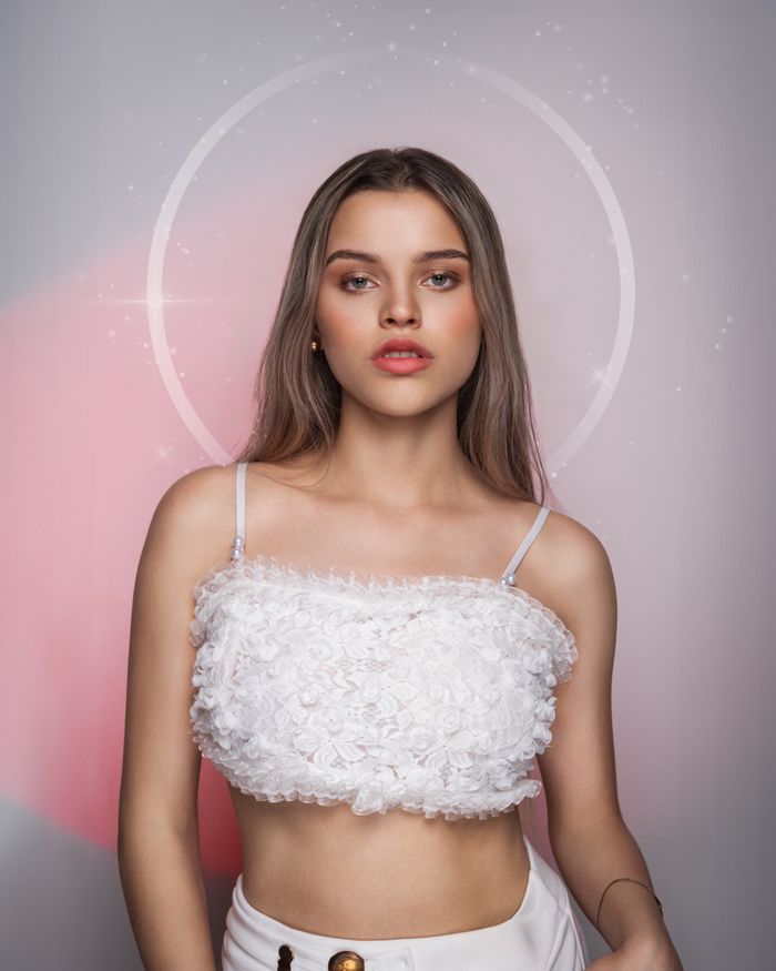 Charming portrait of a woman in a white top with a soft artistic backdrop.